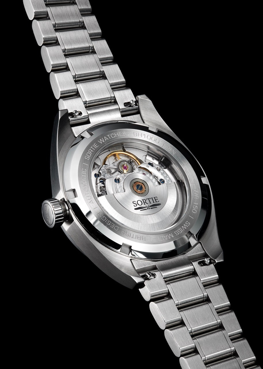 Silver stainless steel watch shown from the back with a visible mechanism shown through an exhibition window. 