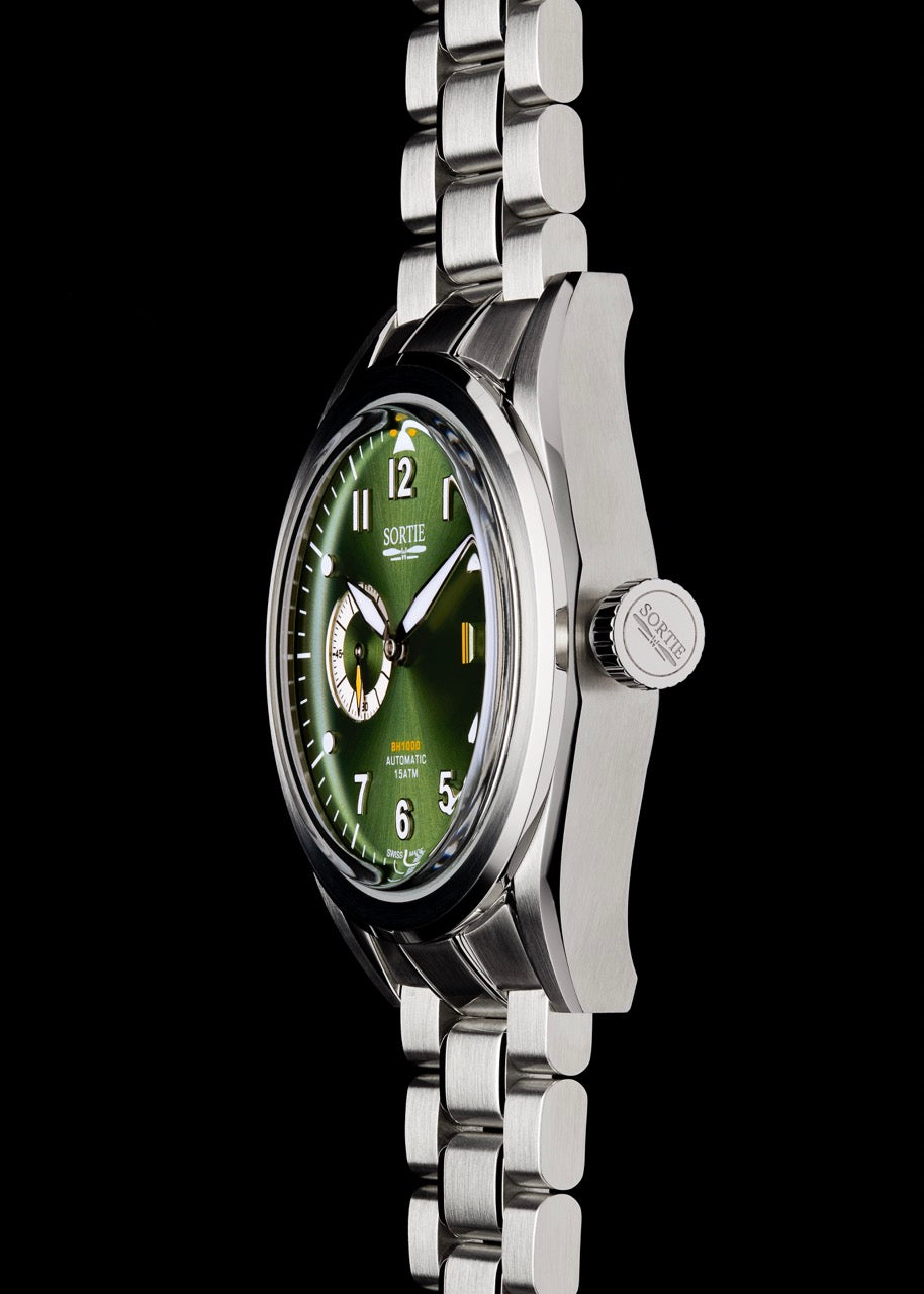 Silver stainless steel watch with a green dial, white numerals and yellow colour accents. Includes a seconds hand dial and date display. Watch is shown from the side.