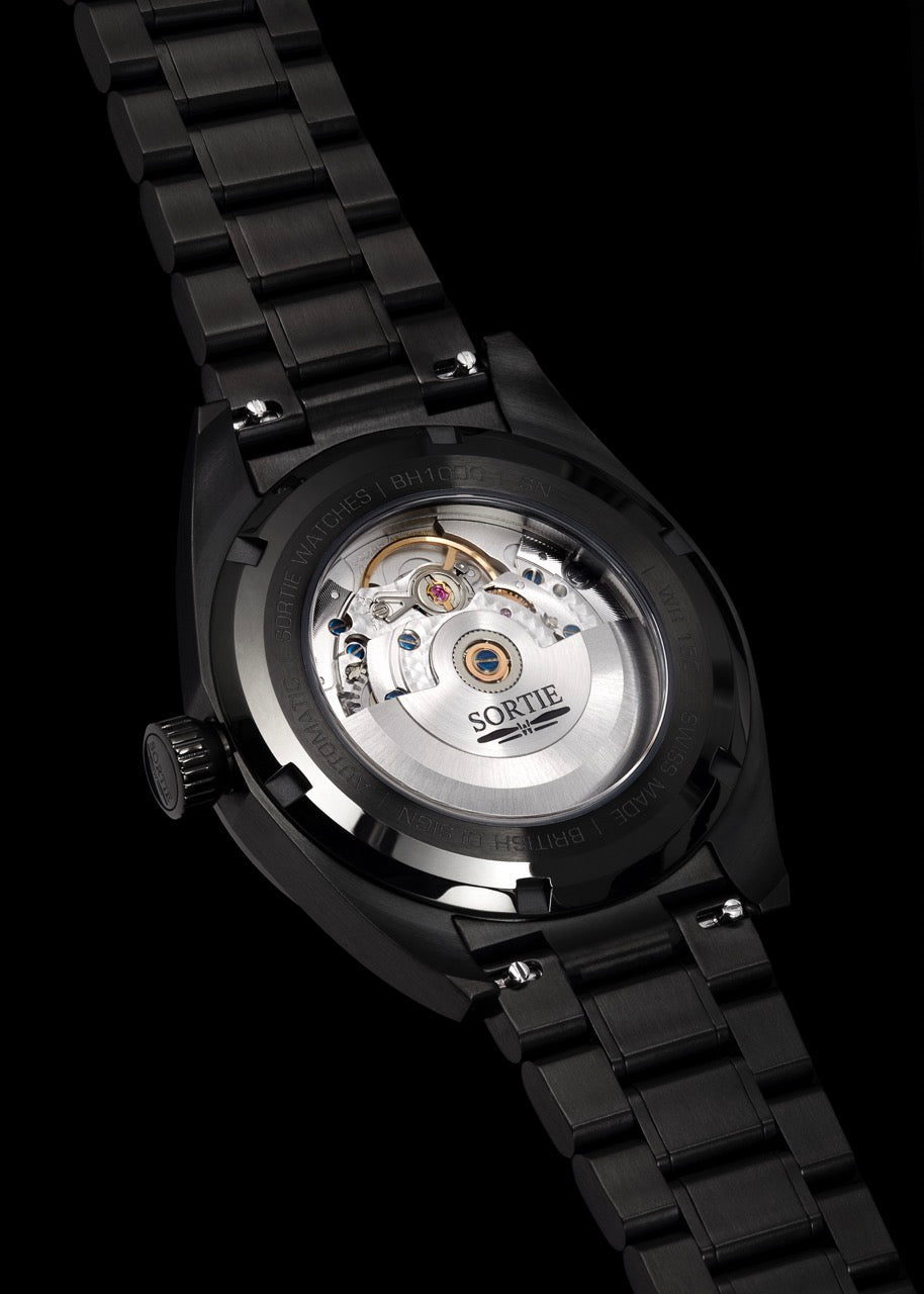 Silver stainless steel watch shown from the back with a visible mechanism shown through an exhibition window. 