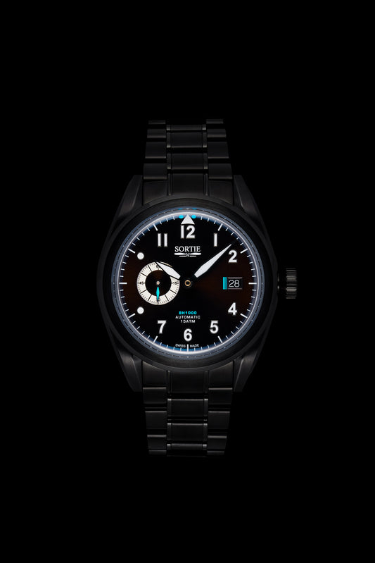 Black watch with a black dial, white numerals and blue colour accents. Includes a seconds hand dial and date display. Watch is shown face-on.