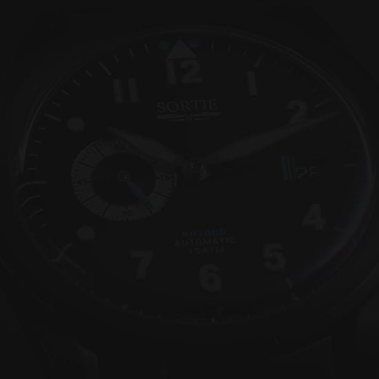 A video showing a black watch with a black dial, white numerals and blue colour accents. Includes a seconds hand dial and date display. The video shows close ups of the watch at different angles.