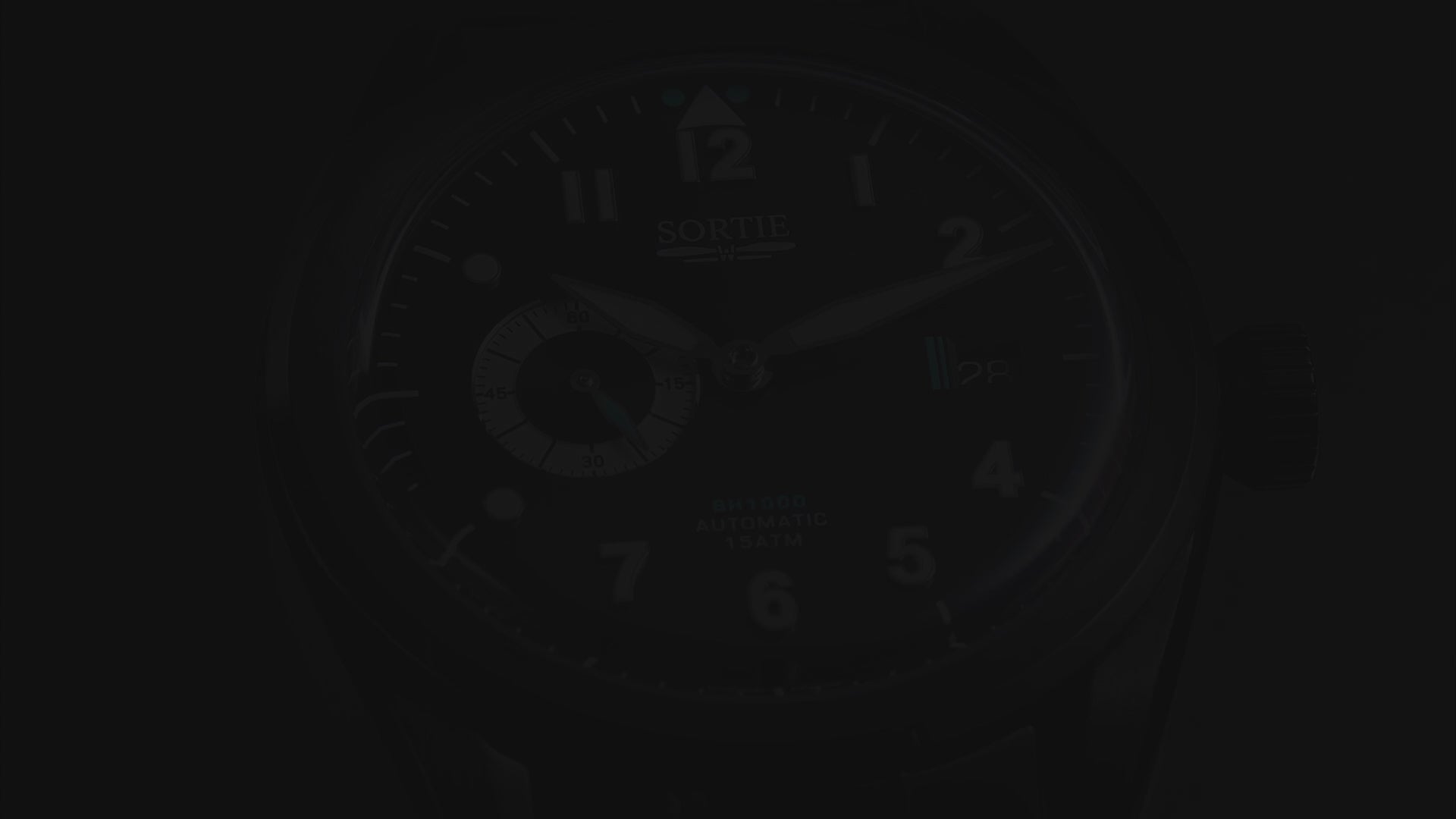 A video showing a black watch with a black dial, white numerals and blue colour accents. Includes a seconds hand dial and date display. The video shows close ups of the watch at different angles.